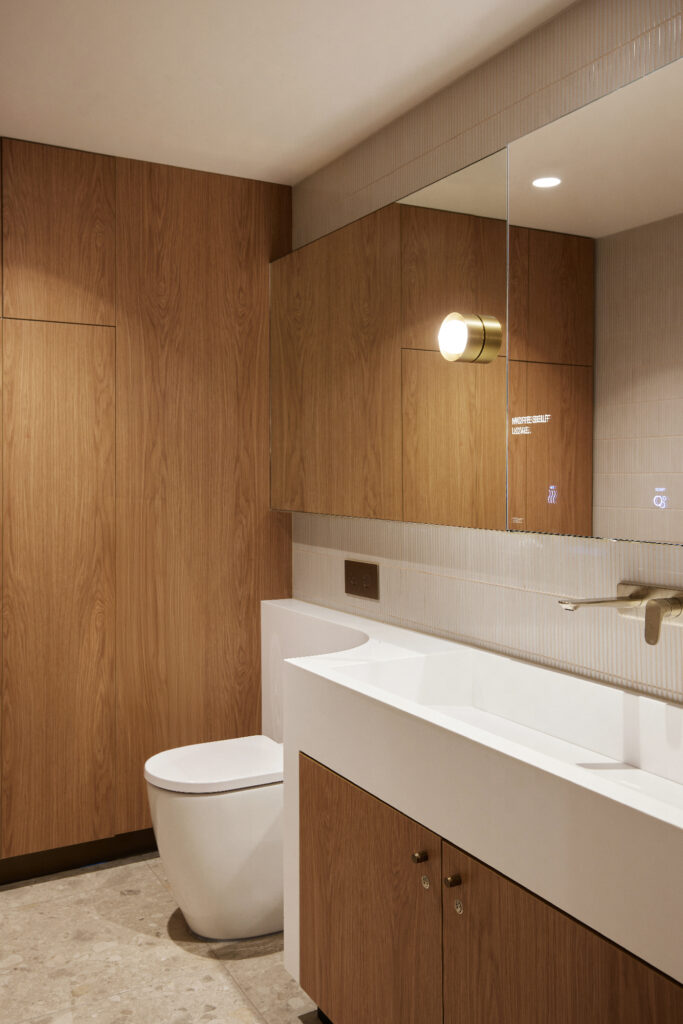 Modern bright interior, wellness, toilet, corian vanity, changing room, American oak timber veneer, finger tiles, stone floor