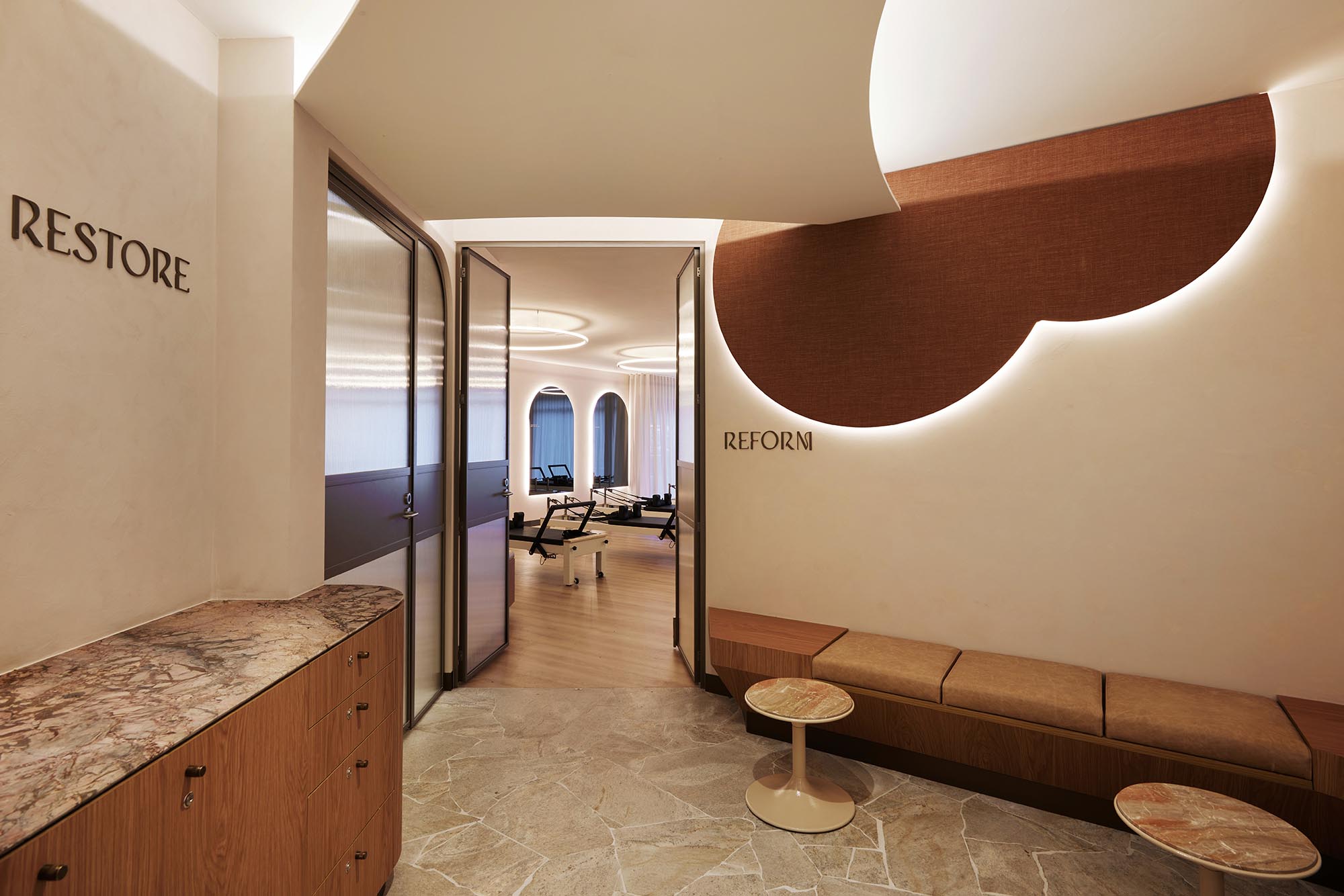 Modern interior, reform pilates, fabric panel, fluted glass, bronze, timber, leather seating, marble, earthy tones, limewash